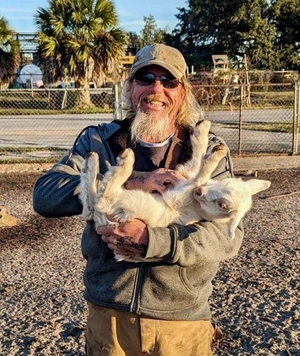 candid man w baby goat Aceto